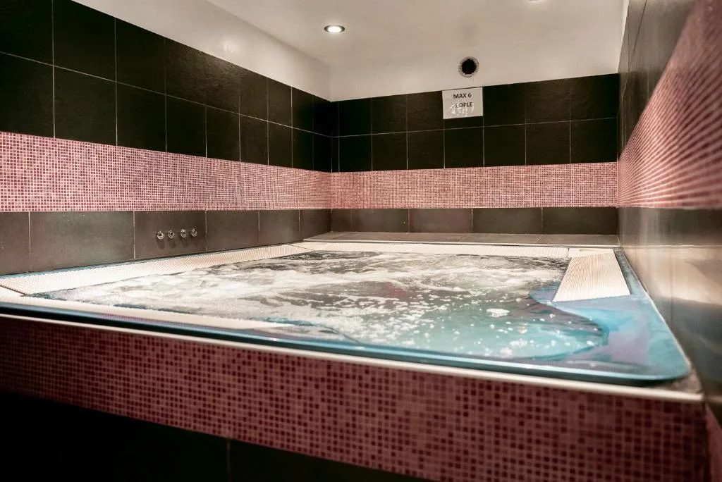 Vasca idromassaggio con rivestimento a mosaico rosa e nero
