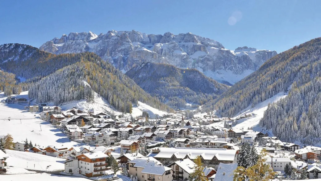 Vista panoramica di un paese di montagna innevato con le Dolomiti sullo sfondo